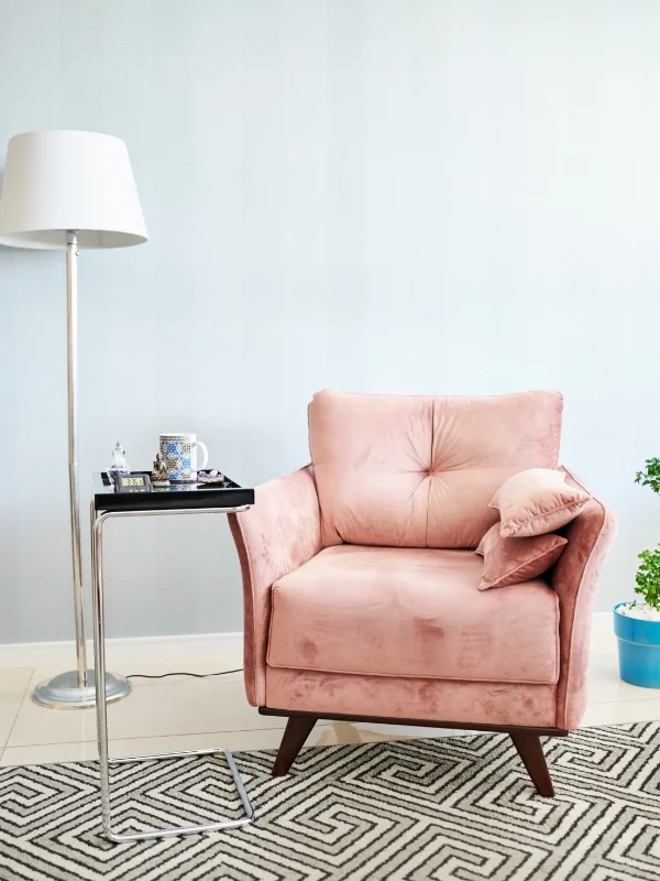 A single pink velvet armchair sits in a therapist's office.