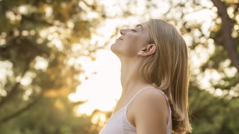 Woman in nature reflecting on emotional healing and navigating attachment needs after trauma.