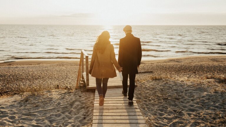 Couple holding hands walking toward the sunlight, symbolizing healing and secure connection