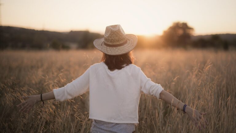 A woman standing in the sunset with arms open wide, symbolizing emotional freedom, self-acceptance, and healing through anxiety counselling and IFS therapy in Vancouver.