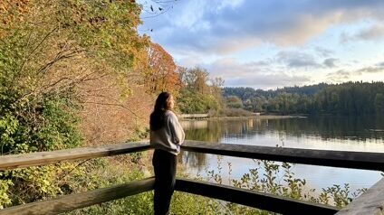A young woman standing in soft light, reflecting quietly — representing the inner journey of healing from childhood trauma.
