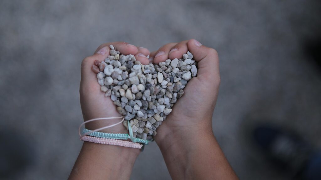“Hands gently holding a blue stone heart, symbolizing inner child healing, emotional safety, and trauma-informed counselling support.”