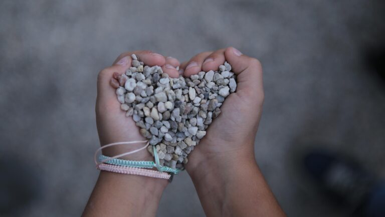 “Hands gently holding a blue stone heart, symbolizing inner child healing, emotional safety, and trauma-informed counselling support.”