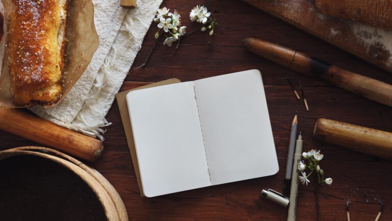 Open journal with blank pages and a pen resting on it, symbolizing emotional expression and therapeutic writing in depression recovery.